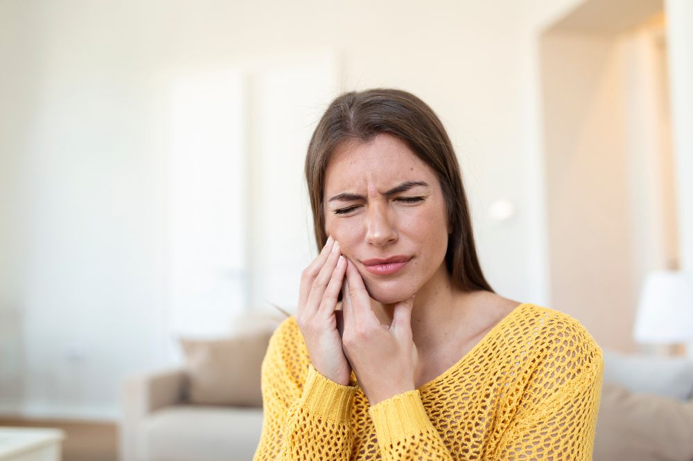 a woman is suffering from tooth pain